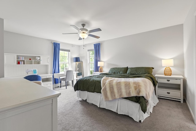 bedroom featuring light colored carpet, a ceiling fan, and baseboards