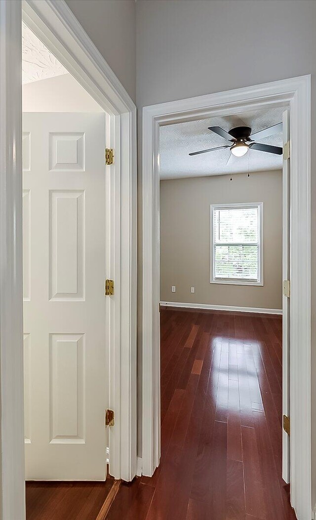 hall with dark wood finished floors and baseboards