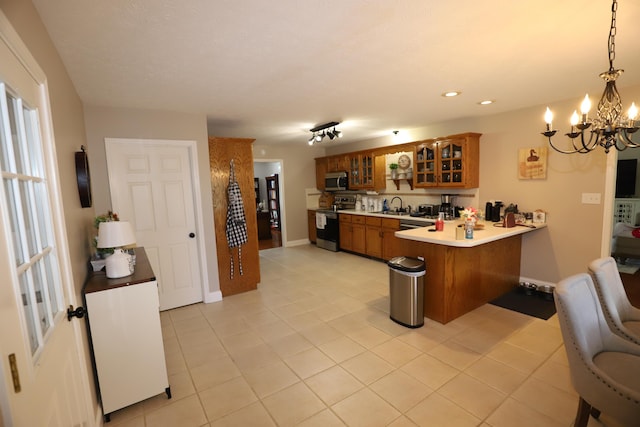 71 View Point Dr, Somerset, KY 42503 - kitchen with appliances with stainless steel finishes, brown cabinetry, a peninsula, a sink, and a chandelier