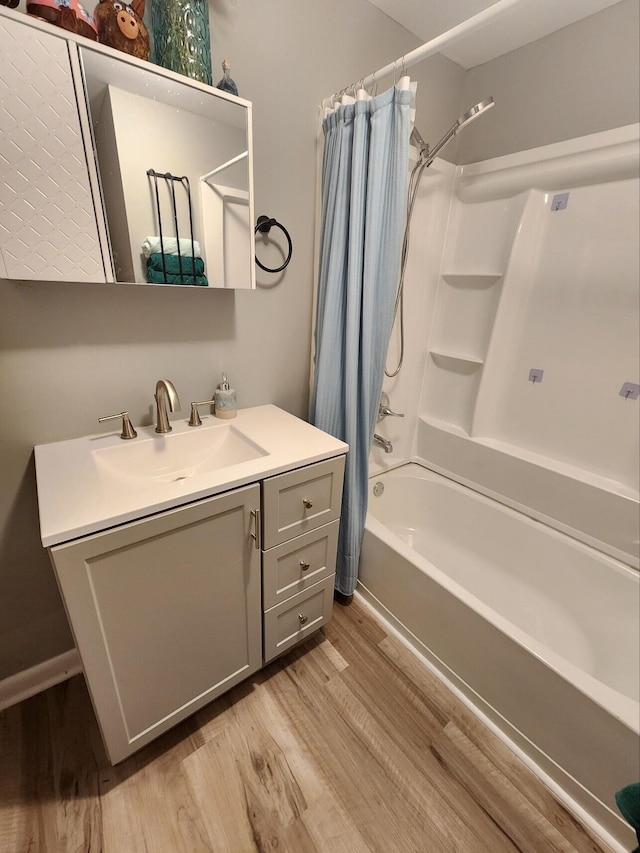 bathroom with wood finished floors, shower / bath combo, and vanity