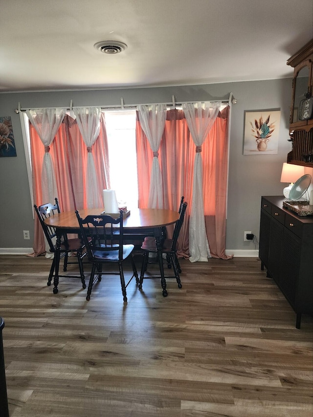 dining room with healthy amount of natural light, baseboards, and dark wood-style floors