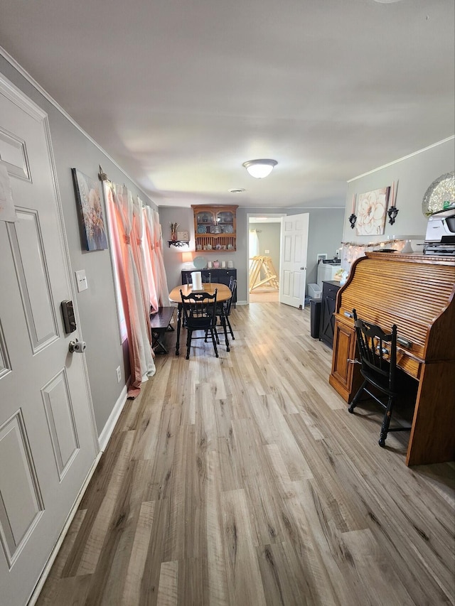 dining room featuring wood finished floors, crown molding, and baseboards