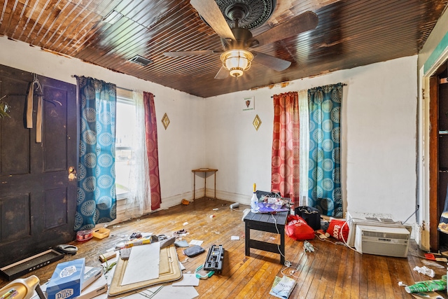 interior space featuring hardwood / wood-style floors, a ceiling fan, and baseboards