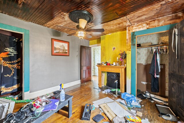 living room featuring a ceiling fan, wooden ceiling, hardwood / wood-style flooring, and baseboards