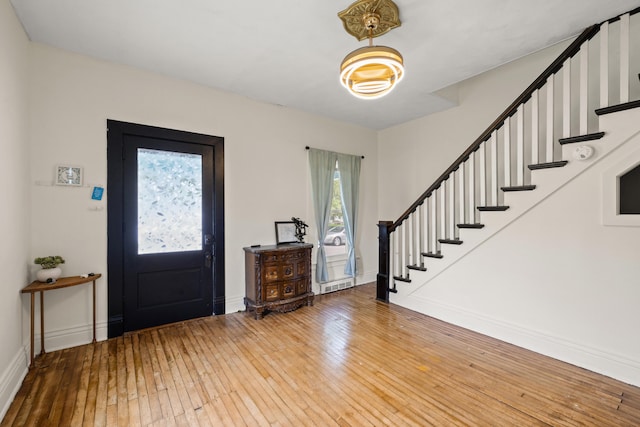 entryway featuring hardwood / wood-style floors, stairway, and baseboards