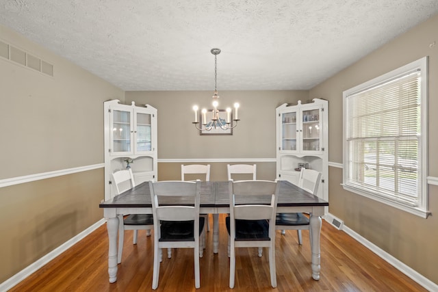 3540 Cornwall Dr, Lexington, KY 40503 - dining room featuring wood finished floors, a chandelier, a textured ceiling, and baseboards
