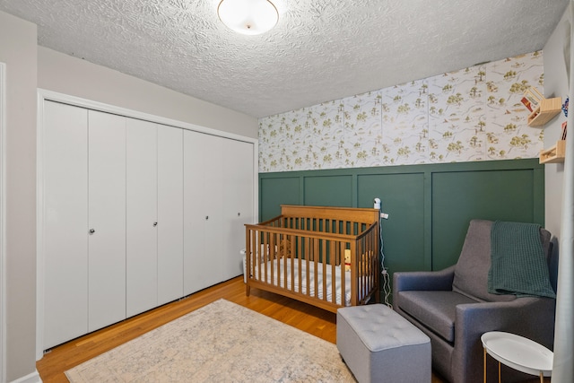 3540 Cornwall Dr, Lexington, KY 40503 - bedroom with wallpapered walls, a closet, wainscoting, wood finished floors, and a decorative wall