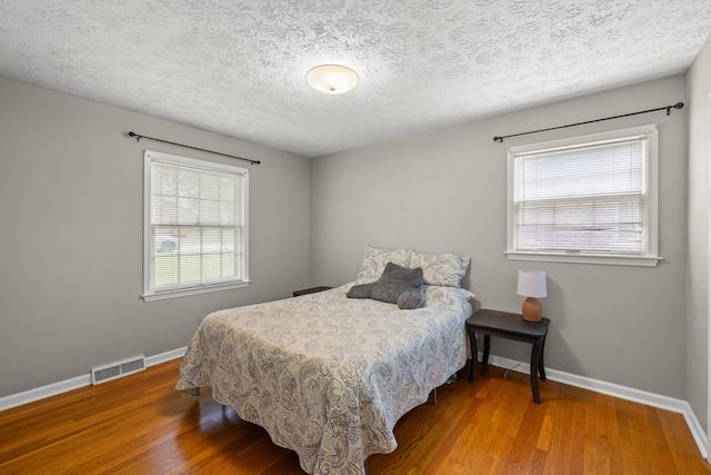 3540 Cornwall Dr, Lexington, KY 40503 - bedroom featuring baseboards, multiple windows, wood finished floors, and a textured ceiling