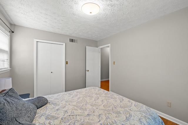 3540 Cornwall Dr, Lexington, KY 40503 - bedroom with a closet, wood finished floors, a textured ceiling, and baseboards
