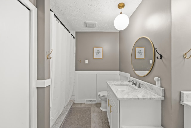 3540 Cornwall Dr, Lexington, KY 40503 - full bathroom with toilet, vanity, a textured ceiling, a shower with shower curtain, and wainscoting