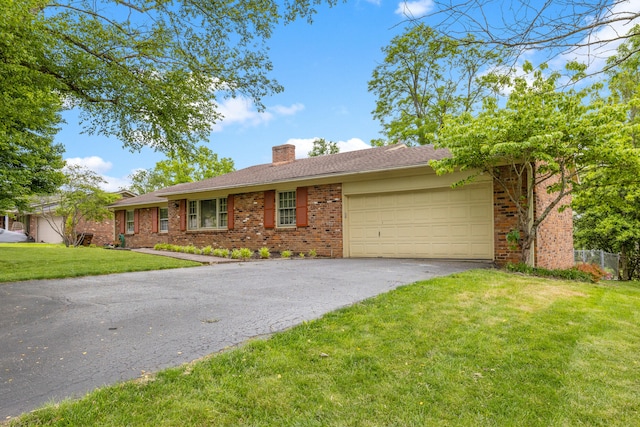 3540 Cornwall Dr, Lexington, KY 40503 - ranch-style house featuring brick siding, asphalt driveway, a chimney, a garage, and a front lawn