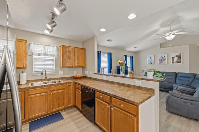 kitchen with a sink, black dishwasher, open floor plan, a peninsula, and light wood finished floors