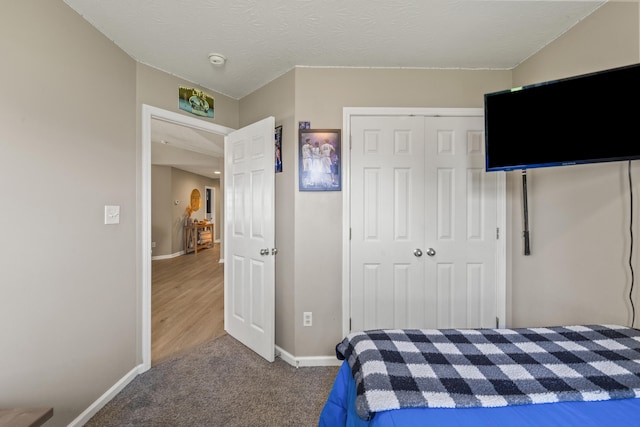 bedroom featuring a closet, baseboards, and carpet flooring