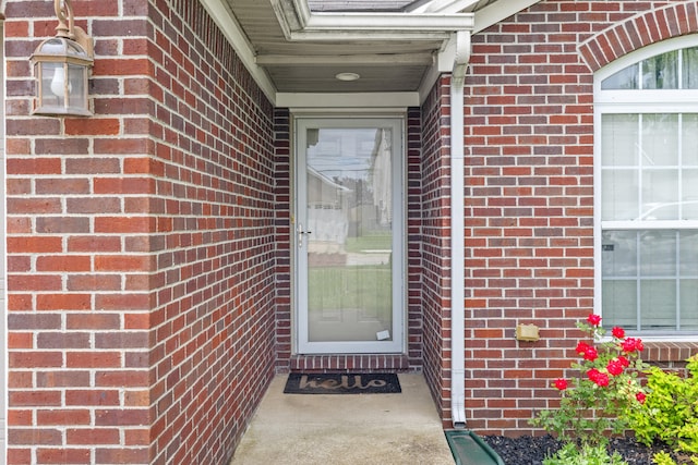 view of exterior entry featuring brick siding