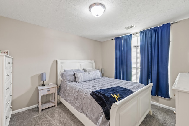 carpeted bedroom with a textured ceiling and baseboards