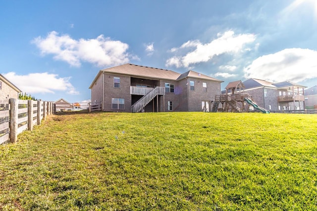 back of property with stairs, brick siding, and a playground