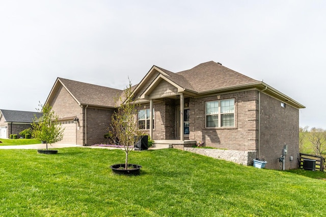 view of front facade with brick siding, an attached garage, a front lawn, and cooling unit