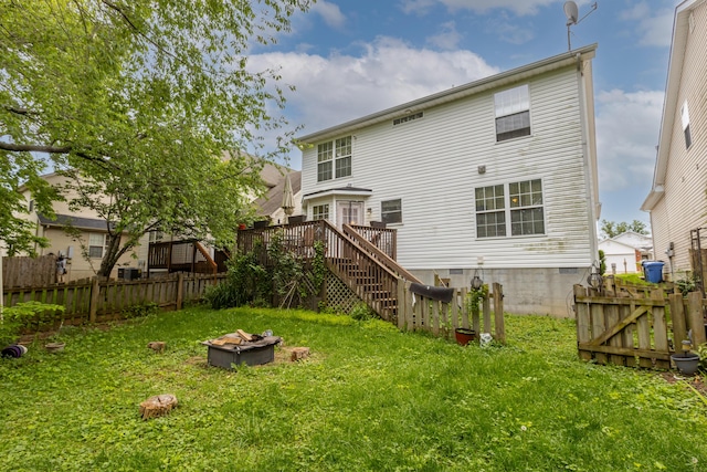 back of property with a fire pit, stairs, and a deck