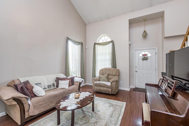 living area with high vaulted ceiling, dark wood-style floors, and baseboards