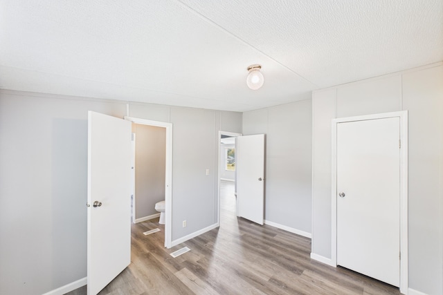 599 Ravenwood Ests, London, KY 40741 - unfurnished bedroom featuring wood finished floors, a textured ceiling, and baseboards