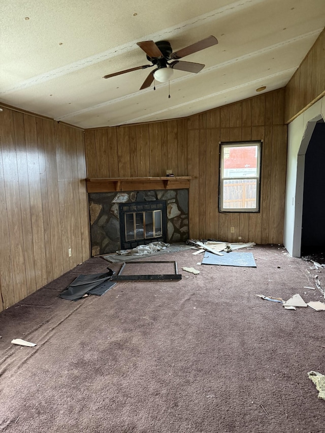 515 Pierce Ln, Frankfort, KY 40601 - unfurnished living room with lofted ceiling, wooden walls, a ceiling fan, carpet floors, and a stone fireplace