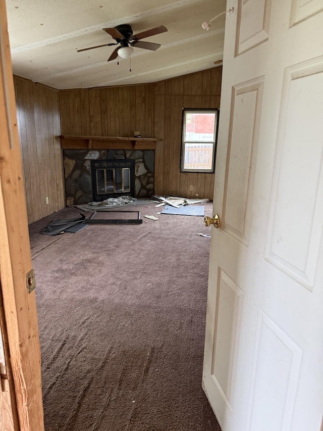 515 Pierce Ln, Frankfort, KY 40601 - unfurnished living room with vaulted ceiling, carpet floors, ceiling fan, wood walls, and a stone fireplace