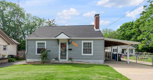 view of front of house featuring concrete driveway, a chimney, a shingled roof, and an attached carport