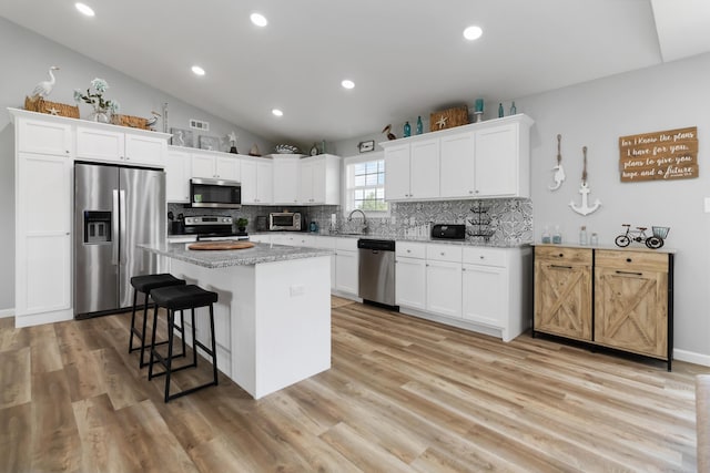 350 Misty Dr, Somerset, KY 42503 - kitchen with stainless steel appliances, tasteful backsplash, lofted ceiling, a kitchen island, and light wood-style flooring