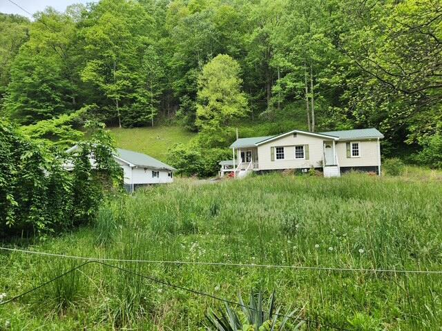 view of front of property featuring a wooded view