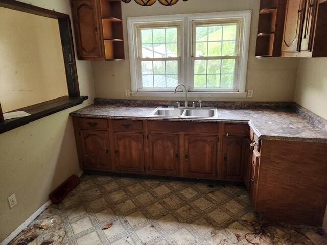 kitchen featuring open shelves, a sink, and light flooring