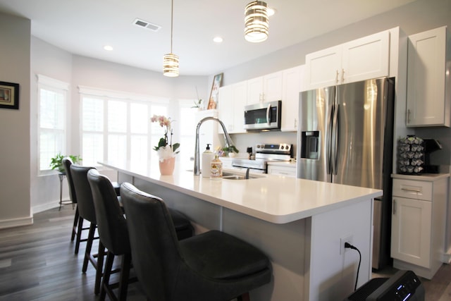 156 Kaydons Way, Somerset, KY 42503 - kitchen with stainless steel appliances, dark wood-style floors, light countertops, a center island with sink, and a kitchen bar