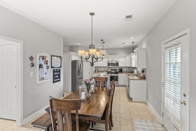 dining area with light tile patterned floors, a chandelier, and baseboards