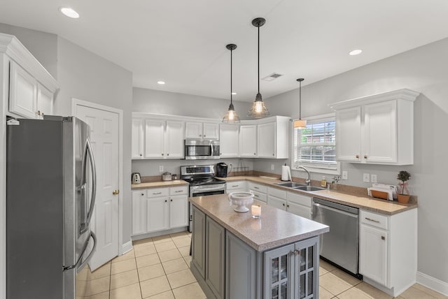 kitchen with appliances with stainless steel finishes, a sink, white cabinetry, light tile patterned floors, and recessed lighting