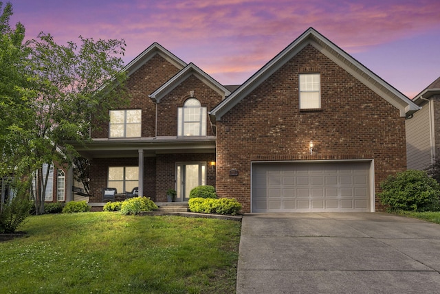 traditional-style home featuring a garage, brick siding, driveway, a yard, and a porch