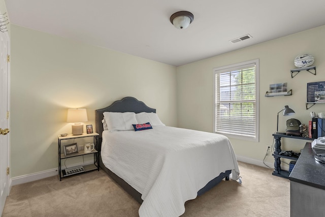 bedroom featuring light carpet and baseboards