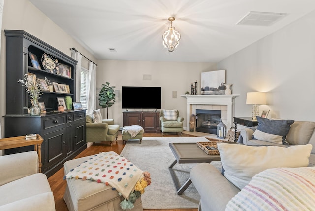 living room with wood finished floors, a fireplace, and a chandelier