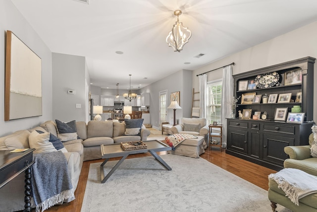 living room with a chandelier and dark wood finished floors