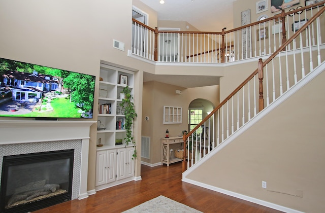 2812 Jenna Rst, Lexington, KY 40511 - living area with a high ceiling, wood finished floors, stairs, a tiled fireplace, and baseboards
