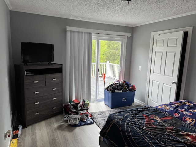 bedroom featuring access to outside, wood finished floors, ornamental molding, and a textured ceiling