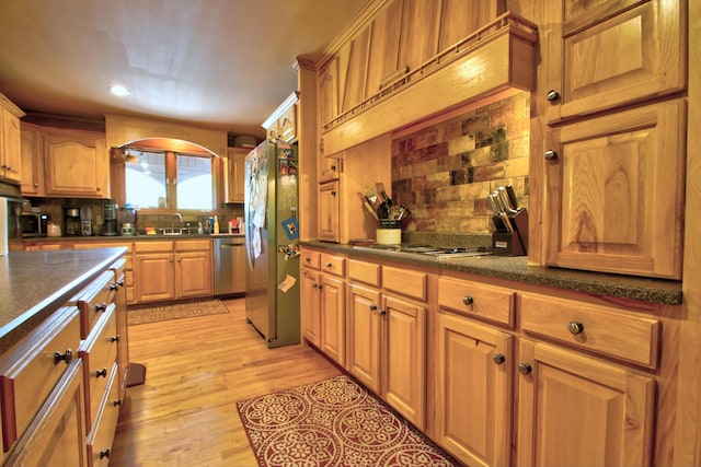 73 Redwood Ln, East Bernstadt, KY 40729 - kitchen featuring appliances with stainless steel finishes, decorative backsplash, a sink, light wood finished floors, and arched walkways