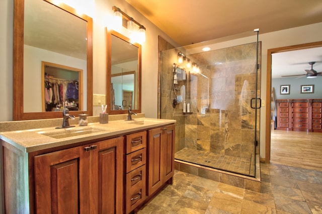 73 Redwood Ln, East Bernstadt, KY 40729 - bathroom with a ceiling fan, a stall shower, double vanity, stone finish flooring, and a walk in closet