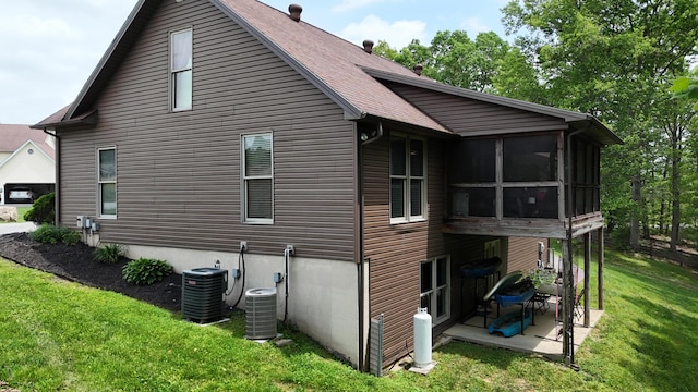 73 Redwood Ln, East Bernstadt, KY 40729 - rear view of property with a patio, central air condition unit, a lawn, a sunroom, and roof with shingles