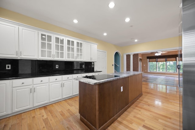 187 Woodside Dr, Somerset, KY 42503 - kitchen with arched walkways, black electric cooktop, ornate columns, a center island, and light wood finished floors