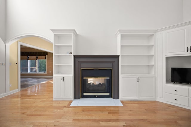 187 Woodside Dr, Somerset, KY 42503 - unfurnished living room with light wood-style flooring, built in shelves, a multi sided fireplace, and baseboards