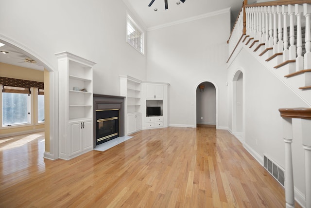 187 Woodside Dr, Somerset, KY 42503 - unfurnished living room with a ceiling fan, light wood finished floors, ornamental molding, arched walkways, and a fireplace with flush hearth