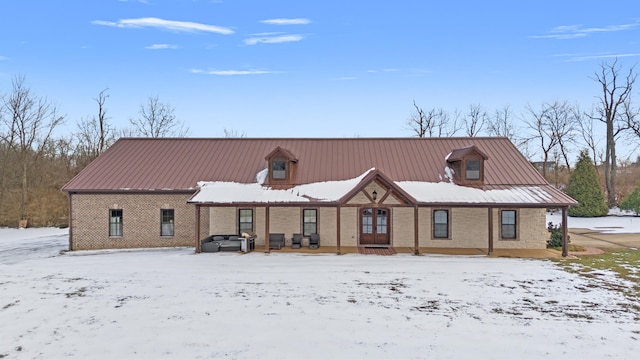 view of front of property with brick siding and metal roof