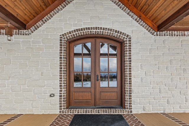 doorway to property featuring french doors and brick siding