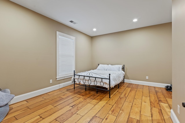 bedroom with light wood-style floors, baseboards, and recessed lighting