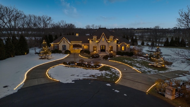 view of front facade featuring curved driveway and stucco siding