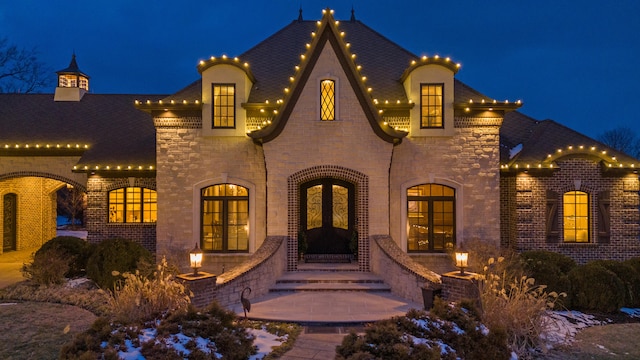view of front of house with brick siding, stone siding, and entry steps